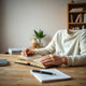 Person reading an open book at a desk with a notebook and pen, practicing focused reading.