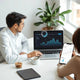 Marketing team reviewing AI-assisted analytics dashboards on laptop and phone in a modern office