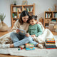 Parent and child reading together on a tablet with colorful kids’ book covers nearby
