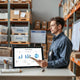 Warehouse shelves and a worker reviewing inventory planning on a tablet with stock flow visuals